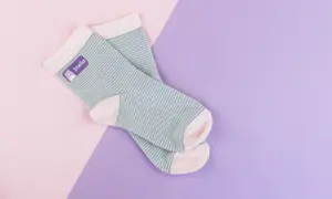 Randiga strumpor med lila stryklapp med texten "Stella"