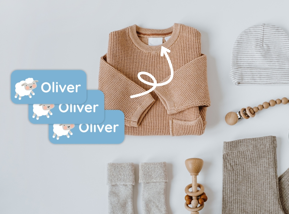 Babykläder och tillbehör med blå namnlappar med ett får och namnet oliver