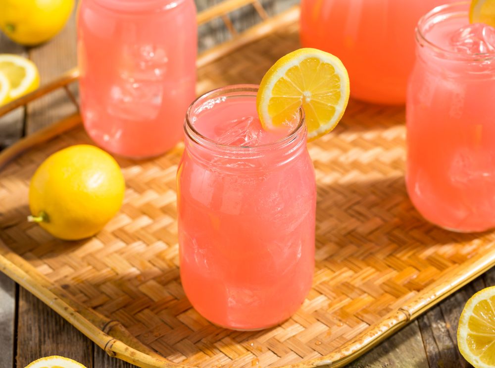 Fräscha sommardrycker för hela familjen – så enkla att göra! 2 Barnvänlig rosa lemonad i en glasburk med is och citronskiva