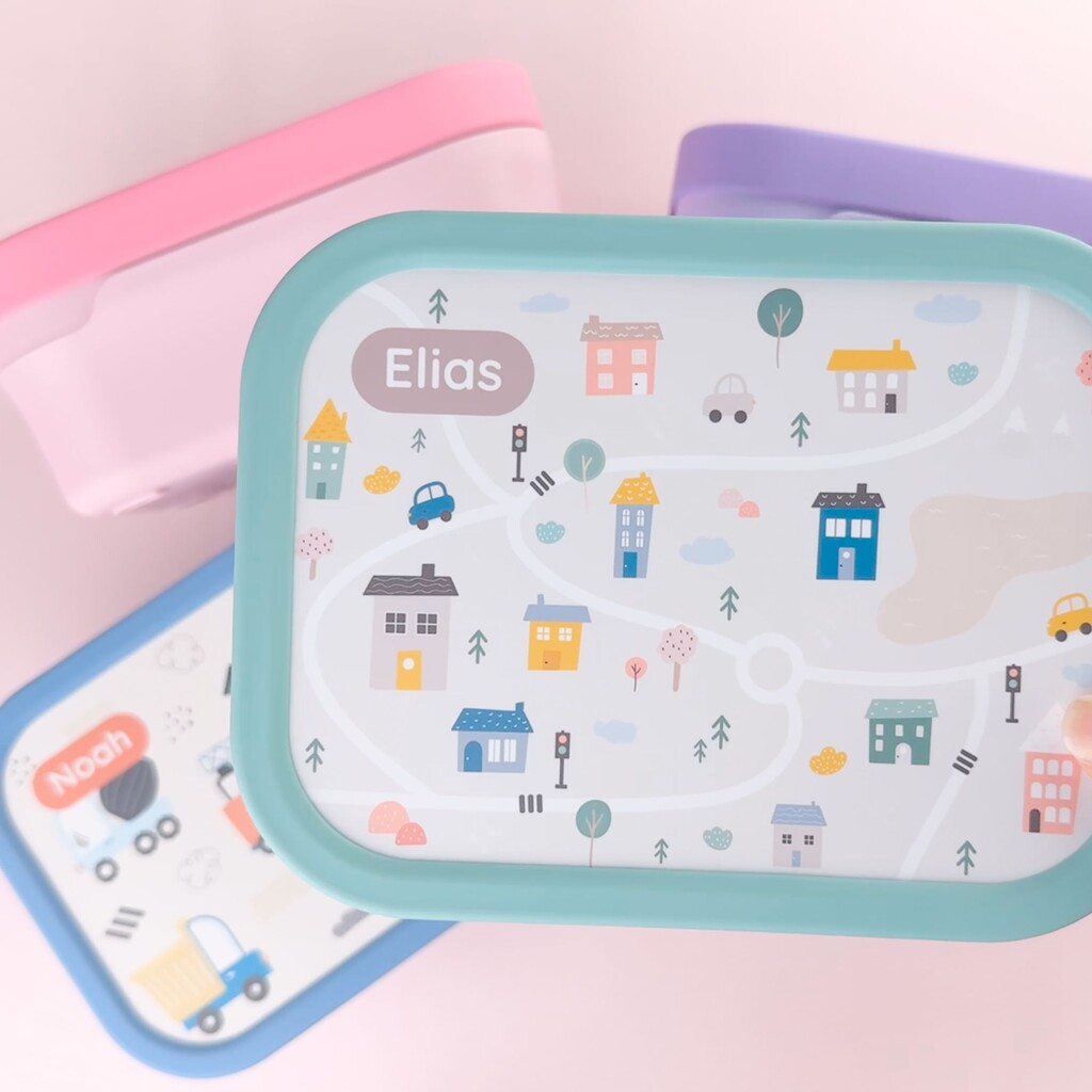 Färgglada matlådor med lekfull stadskarta-design och personligt namn på locket