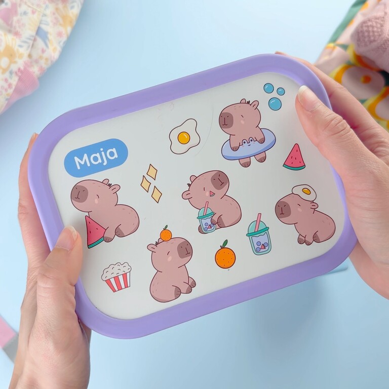 Lila matlåda med namn och capybara-design