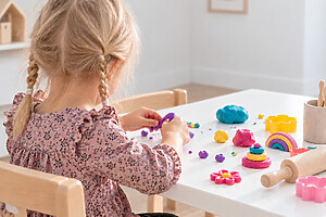 Barn leker med färgglad modellera vid ett bord
